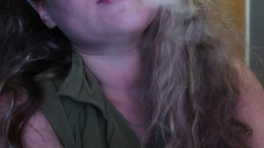 ADORABLE WOMAN PAINTS HER LIPS RED AND SMOKES a CIGARETTE