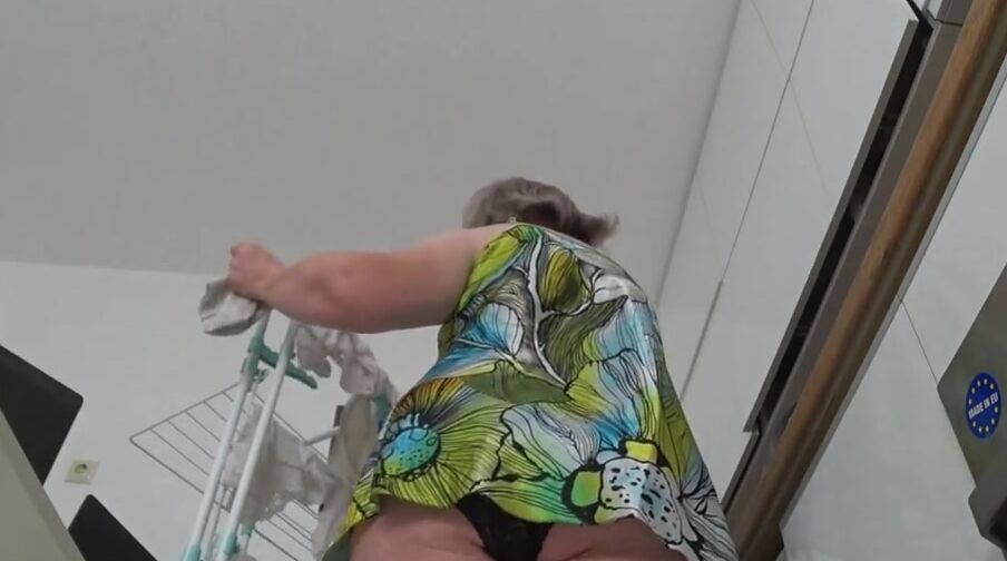 Gigantic butt under a short skirt. Older MILF does housework,